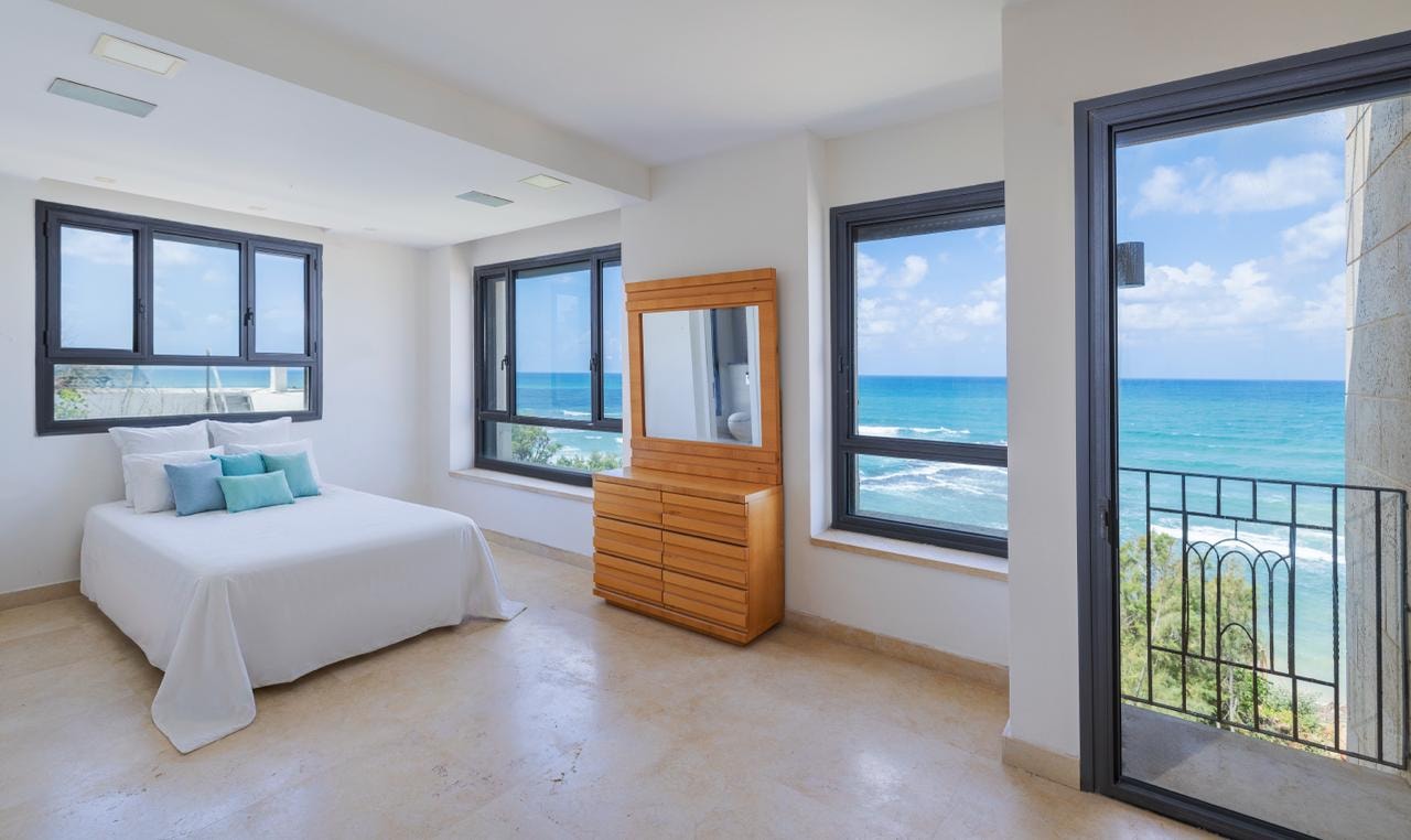Master bedroom with floor-to-ceiling sea views and private balcony