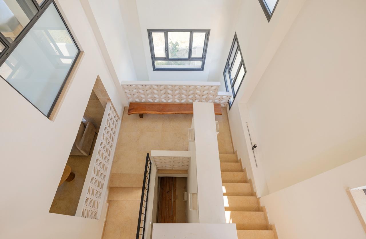 Interior staircase with ornate mashrabiya balustrade and skylights